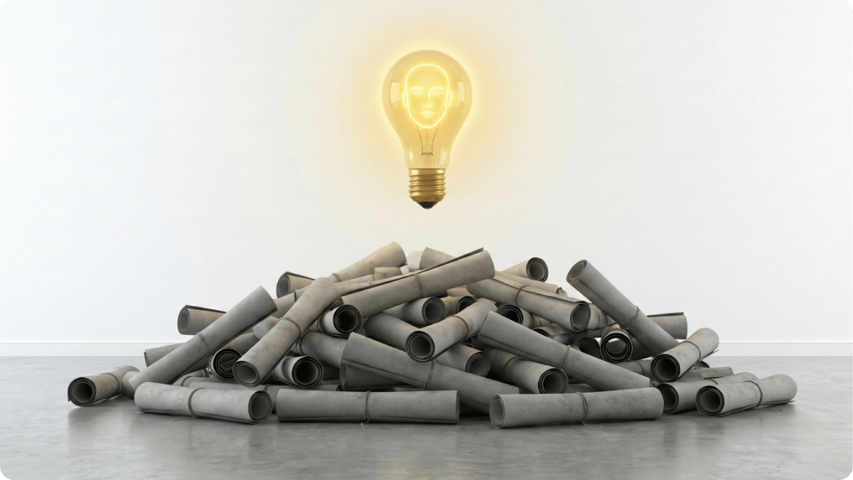 Bombilla brillante destacando sobre una pila de diplomas, representando la importancia de las habilidades personales